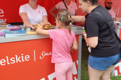 Kobieta i mała dziewczynka przeglądają foldery ułożone na stoisku promocyjnym