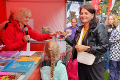 Kobieta z małą dziewczynką podchodzą do stoisk promocyjnego