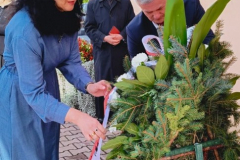 Prof. Sabina Bober i Sekretarz Tadeusz Szymanek składają wieniec z kwiatów pod tablicą pamięci