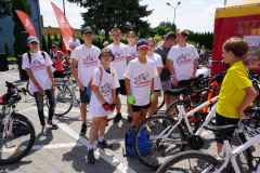 Kilkoro dzieci, które są uczestnikami wyścigu stoją na placu i pozują do zdjęcia, ubrane w koszulki z  napisem Tour de Lubelskie