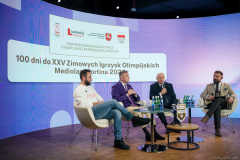 Marszałek Województwa Lubelskiego Jarosław Stawiarski, Radosław Piesiewicz Prezes Polskiego Komitetu Olimpijskiego, Konrad Niedźwiedzki polski panczenista i Olimpijczyk i prowadzący siedzą na krzesłach przy stoliku podczas konferencji, w tle widoczny jest napis 100 dni do XXV Zimowych Igrzysk Olimpijskich Mediolan i Cortina 2026