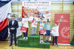 Drużyna chłopców z najmłodszych klas szkolnych stoi na podium i prezentuje zdobyte  medale