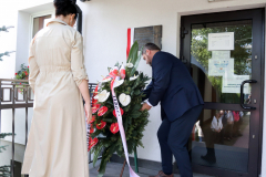 Prof. Sabina Bober wspólnie z Wójtem Gminy Dorohusk składa wieniec pod tablicą pamięci, która jest powieszona na zewnątrz budynku