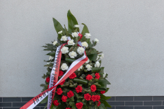 Wieniec złozony pod powieszoną tablicą pamięci