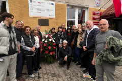 Uczestnicy odsłonięcia tablicy pamięci pozujący do wspólnego zdjęcia przed tablicą. Wśród nich, między innymi, Lea Hirsch oraz Żydzi z Izraela.