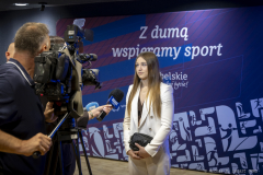 Zdjęcie przedstawia Julię Szeremetę pięściarę i wicemistrzyni olimpijską z 2024 roku, udzielającą wywiadu na ściance z napisem z dumą wspieramy sport