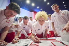 kilku młodych chłopców, zawodników sportowych podczas podpisywania koszulek