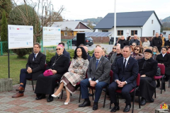 Marszałek Jarosław stawiarski, prof. Sabina bober i biskup Mieczysław Cisło, siedzą na krzesłach ustawionych na placu na zewnątrz razem z nimi siedzi na placu około dwudziestu innych uczestników