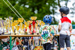 Dwójka młodych rowerzystów podziwia liczne puchary czekające na wręczenie uczestnikom maratonu.
