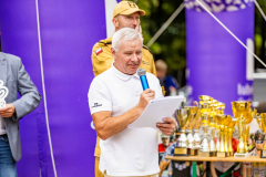 Jeden z organizatorów maratonu odczytujący treść trzymanych zapisów do mikrofonu.