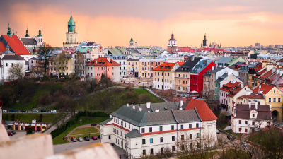 Panorama miasta Lublin z wysokiego punktu. Widoczne są liczne kamienice starego miasta ponad którymi pną się wieżyce zabytkowych budynków sakralnych.